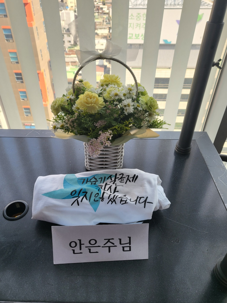 故 안은주님의 자리에 마련된 꽃과 기억 티셔츠. (사진=소재원 작가 제공)