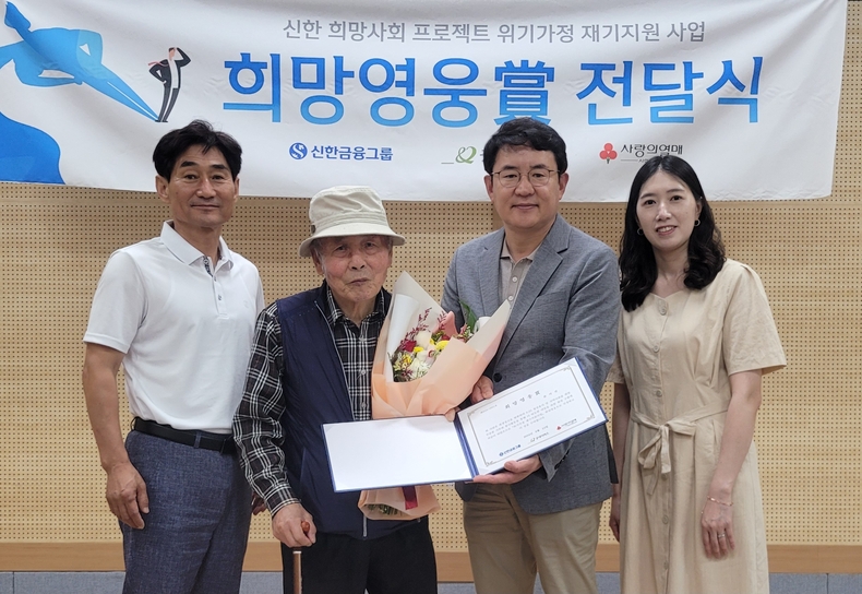 신한금융그룹은 13일 오후 강원도 원주에 위치한 귀래면사무소에서 76번째 ‘희망영웅상’ 전달식을 가졌다. 박창호 귀래면사무소 부면장(왼쪽부터), 희망영웅 손이선씨, 최영환 신한은행 원주커뮤니티 단장, 김현희 굿네이버스 팀장이 전달식 후 기념촬영을 하고 있다.(사진=신한금융그룹)