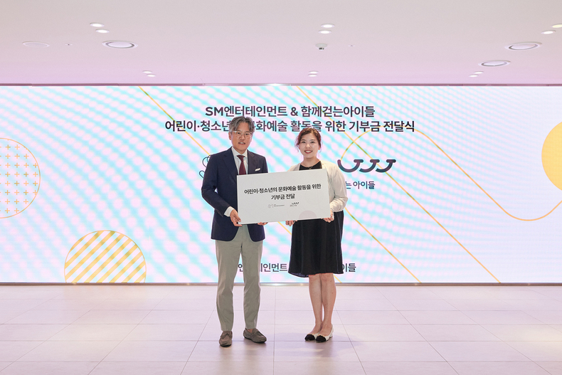 장철혁 SM공동대표(왼쪽)와 김현주 함께걷는아이들 국장 기부금 전달식 모습/사진=SM엔터테인먼트 