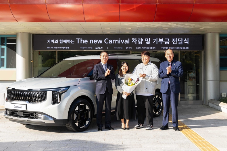 ‘The 2025 카니발’ 9인승 차량 전달식에서 기아 국내사업본부장 정원정 부사장(왼쪽부터)과 사공혜란·김준영 부부, 박형덕 동두천시장이 기념 사진을 촬영하고 있다.(사진=기아)