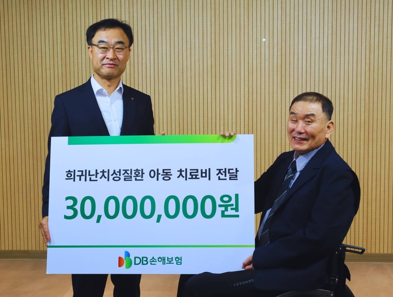 박성식 DB손해보험 부사장(왼쪽)과 김재학 한국희귀난치성 질환 연합회 회장이 지원금 전달식 후 기념촬영을 하고 있다.(사진=DB손해보험)