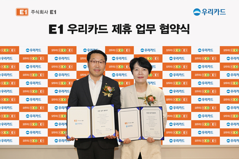 박명신 우리카드 개인영업본부장(오른쪽)과 김수근 E1 영업본부장이 업무 제휴 후 기념사진을 촬영하고 있다.(사진=우리카드)